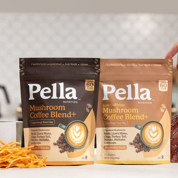 Pella Regular and Low Caffeine mushroom coffee with a cup of coffee