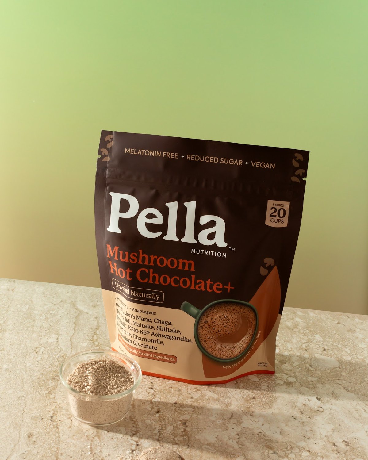 A spoonful of cocoa powder above the Mushroom Hot Chocolate+ bag