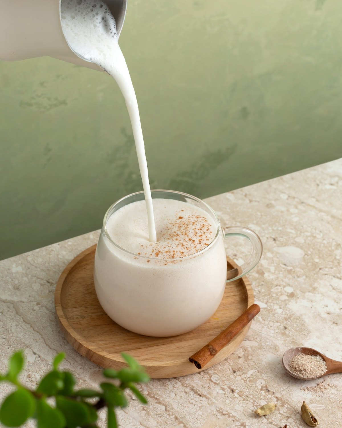 Steamed milk being poured into a glass of Mushroom Spiced Chai+