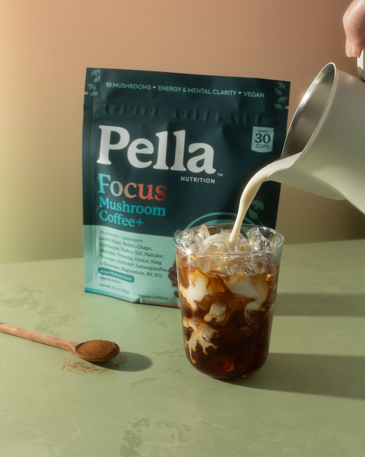 Milk being poured into an iced Focus mushroom coffee next to the Focus bag