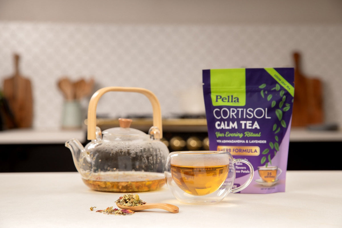 Cortisol Calm Tea pouch beside a glass teapot and a cup of tea