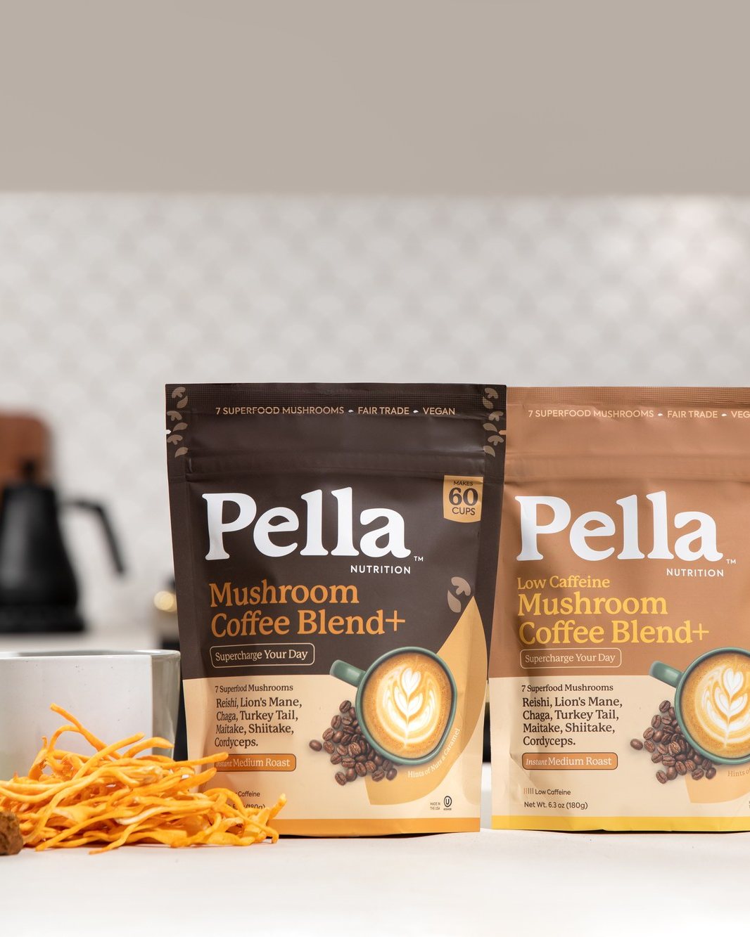 Pella Mushroom Coffee Regular and Low Caffeine bags on a bright kitchen counter