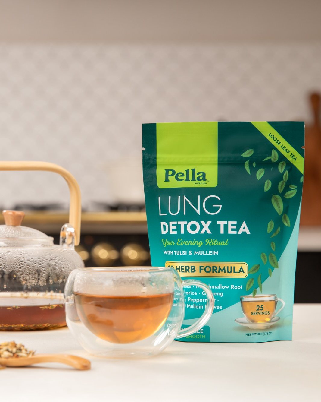 Lung Detox loose leaf tea pouch beside a glass teapot and a cup of tea